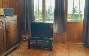une télévision assise sur une table dans une pièce avec fenêtres dans l'établissement 3 Bedroom Cozy Home In yer, à Øyer