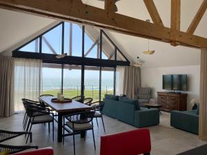 een grote woonkamer met een tafel en stoelen bij Hôtel Le Lichen De La Mer in Batz-sur-Mer