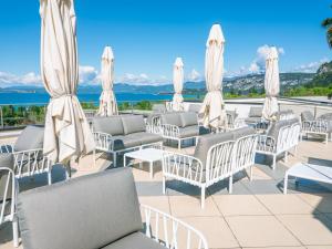 a group of chairs and umbrellas on a patio at Parc Hotel Germano Suites & Apartments in Bardolino