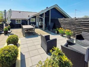 a patio with a table and chairs and a house at Three-Bedroom Holiday home in Hemmet 26 in Hemmet