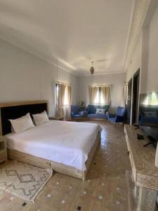 a bedroom with a large bed and a living room at Dar Lily, villa familiale avec piscine et services in Skoura