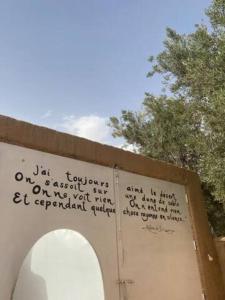 a wall with writing on it next to a toilet at Dar Lily, villa familiale avec piscine et services in Skoura