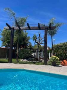 a blue swimming pool with a wooden pergola at Cafofos da Zeta, Cozy Pool House in Quinta do Conde