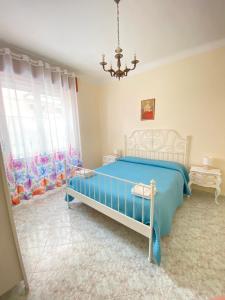 a bedroom with a blue bed and a chandelier at Affittacamere Benvenuti Monterosso in Monterosso al Mare