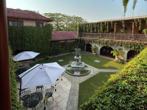 a courtyard with a fountain and chairs with umbrellas at Hotel del Patio in Flores