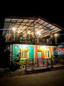 ein farbenfrohes Haus mit einem Zaun davor in der Unterkunft Klub Safari Inn & Lounge in Tagbina