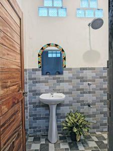 a bathroom with a sink and a tv on the wall at Klub Safari Inn & Lounge in Tagbina