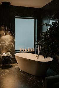bañera en el baño con ventana en Hotel Muntele Mic, en Borlova