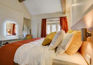 a bedroom with a large bed with yellow pillows at TLasses Cottage in Kildwick