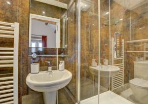 a bathroom with a sink and a shower and a toilet at TLasses Cottage in Kildwick