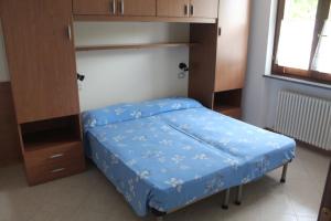 a small bedroom with a bed with a blue cover at Residence Panorama in Molina di Ledro