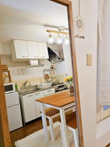 eine Küche mit weißen Schränken und einem Holztisch in der Unterkunft 歌舞伎町704 in Tokio