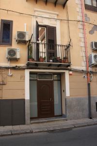- Edificio con puerta marrón y balcón en DUE CAPPUCCINI en Palermo