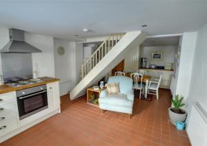 a kitchen and living room with a staircase in a house at Thornwick Cottage in Staithes