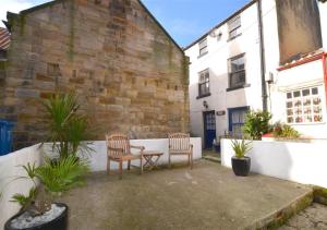 two chairs and a table in front of a building at Thornwick Cottage in Staithes