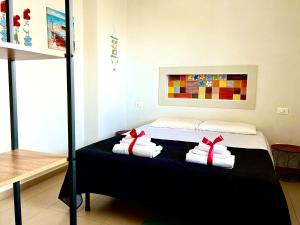 um quarto com uma cama com toalhas em Suite Petrelli em Torre dell'Orso
