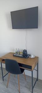 Pokoje do wynajęcia في توماسزوو مازوويكي: مكتب خشبي عليه كرسي وشاشة