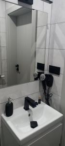 Pokoje do wynajęcia في توماسزوو مازوويكي: حمام مع حوض أبيض ومرآة