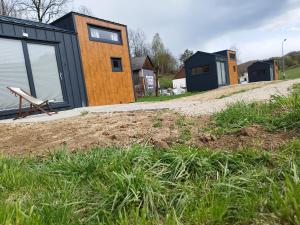 a row of houses on a hill with grass at Gospodarstwo Agroturystyczne Sunny Camp in Jerzmanowice