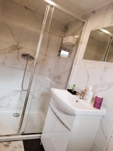 a white bathroom with a sink and a shower at Gospodarstwo Agroturystyczne Sunny Camp in Jerzmanowice