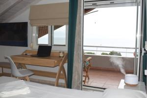 Pokój z łóżkiem i biurkiem z laptopem w obiekcie Alexandros Seaside Family Apartments & Villas - Paradise, 7' from Petalidi w mieście Kalamaki