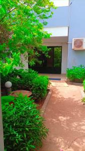 ein Gebäude mit einem Hof mit Pflanzen und einem Baum in der Unterkunft Le Tounkaranké résidence de Fasso Kanu - Villa- in Bamako