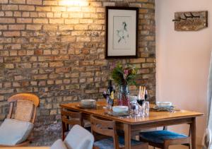 a dining room table with a brick wall at The Stables at The Foldyard in Holme upon Spalding Moor