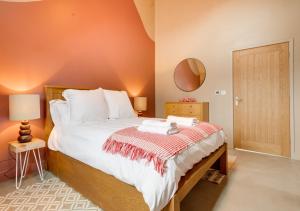 a bedroom with a large bed and a mirror at The Stables at The Foldyard in Holme upon Spalding Moor