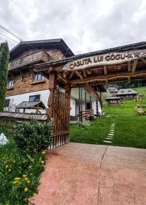 a wooden gazebo in front of a building at Căsuța lui Gogu in Borsa