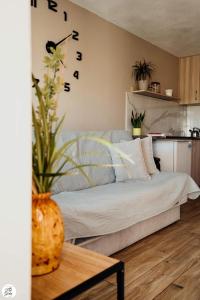 1 dormitorio con 1 cama y un jarrón con flores en Apartament Pod Górką Gołdap, en Gołdap