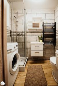 ein Badezimmer mit einer Waschmaschine und einem Waschbecken in der Unterkunft Apartament Pod Górką Gołdap in Goldap