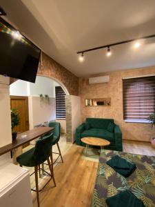 a living room with a green couch and a table at Delux Apartman in Požarevac