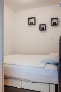 Bett in einem Zimmer mit zwei Bildern an der Wand in der Unterkunft Heaven Spa Apartment in Kranj