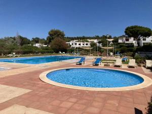 a swimming pool with lounge chairs and a swimming pool at Parque Mourabel, Oásis Village & Pé do Lago in Vilamoura