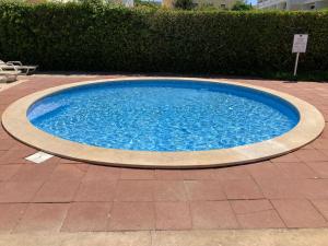 a large blue swimming pool on a brick patio at Parque Mourabel, Oásis Village & Pé do Lago in Vilamoura