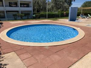 a large blue pool on a brick patio at Parque Mourabel, Oásis Village & Pé do Lago in Vilamoura