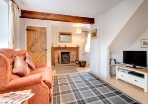 a living room with a couch and a fireplace at The Shippon in Askrigg in Askrigg