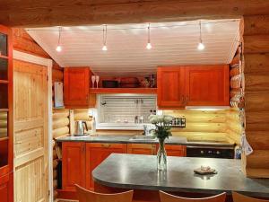 una cocina con armarios de madera y una mesa con un jarrón de flores en Holiday home Gratangen II, en Gratangen
