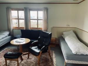Cette chambre comprend un lit, un canapé et une table. dans l'établissement Nye Heimen Overnatting, à Namsos