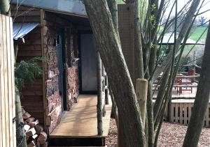 a wooden walkway leading to a cabin with trees at Old Oak Farm in Oakham