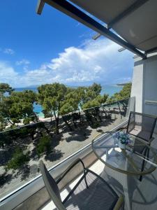 balcone con tavolo, sedie e vista sull'oceano di Luxury apartment in Hotel a Makarska