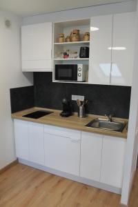 a kitchen with white cabinets and a sink at El Ático de la Estación in Oviedo
