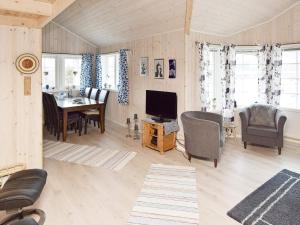 Holiday home Laukvik III في Laukvik: غرفة معيشة مع تلفزيون وغرفة طعام