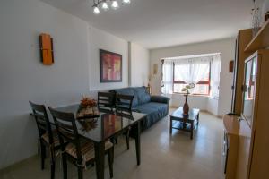 a living room with a table and a blue couch at TORREMAR 17-E Levante Beach in Benidorm