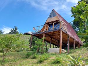 a building with a roof on top of a hill at Glamping Cabaña el Porvenir 10601 in Manta