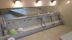 y baño con bañera, lavabo y espejo. en ライダーハウス　レッドSUN, en Shimonoseki