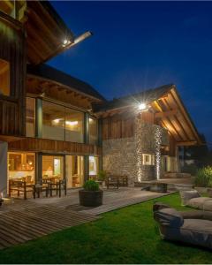 a large house with a wooden deck at night at Chalet Le Coccole in Sappada