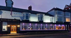 a large white building with purple lights in front of it at Kingsway Hotel. in Cleethorpes