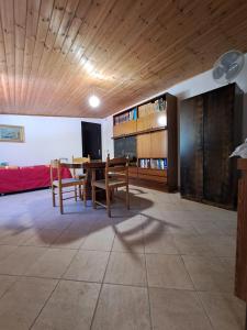 a living room with a wooden ceiling and a table and chairs at Casa Solanas N. 2 in Solanas
