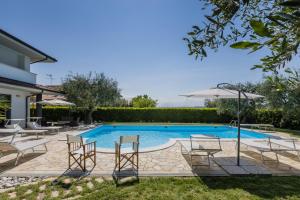 uma piscina com cadeiras e um guarda-sol em Villa Pepe em Molino di Ripe